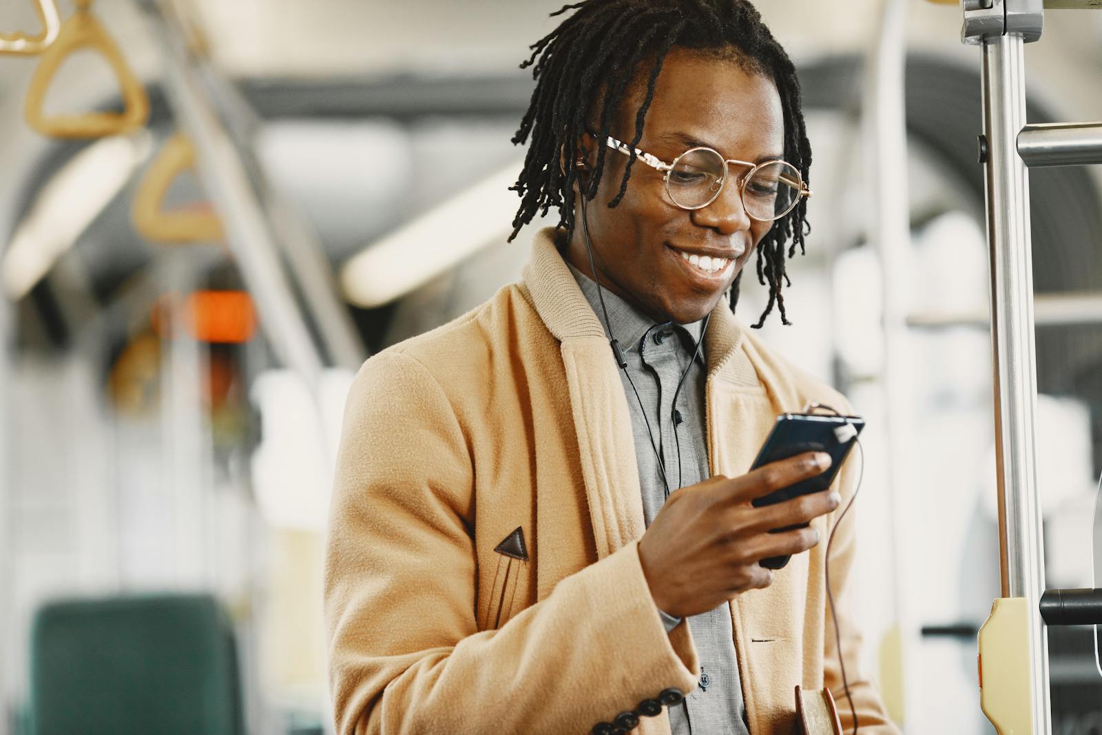 A man smiling as he checks his phone.