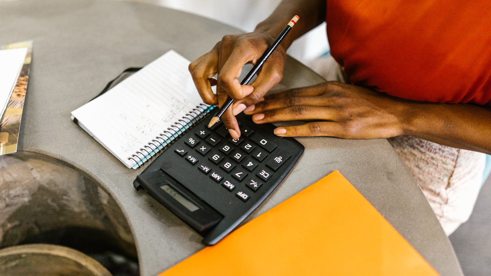A woman reviewing her budget with calculator and notepad